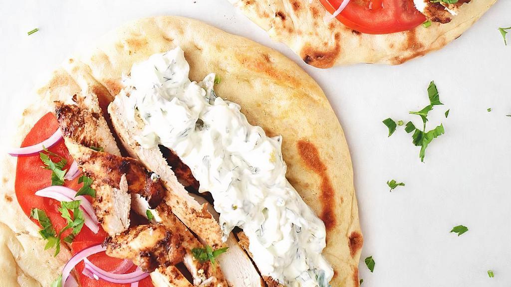 Chicken Gyro · Chicken Gyros  the classic Greek  sandwich, with meat cut from a spit, wrapped in a pita, onions, tomatoes and topped with tzatziki (yogurt sauce)