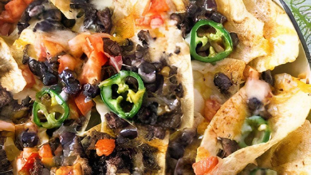 Ground Beef Nachos · Classic ground beef nachos with melted cheese, pico de gallo, beans, and your choice of toppings.