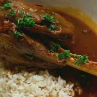Lamb Shank · Tender and seasoned leg of lamb oven baked and served with rice.