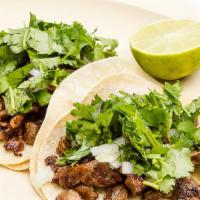 Handmade Tacos · Three handmade corn tortillas. Taco topped with cilantro, onions, and choice of meat.