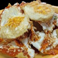 Chilaquiles Salsa Roja · Fried tortilla chips topped with salsa, cheese, sour cream, onions, eggs, and choice of meat.