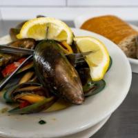 Mussels Full · A heaping crock of wine and herb-steamed mussels served with lemons and brown bread.
