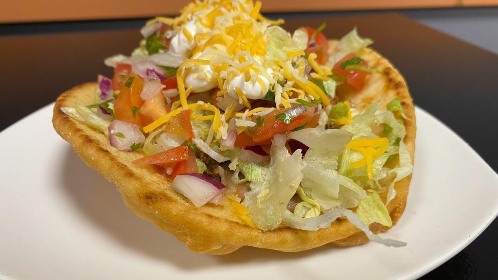 Chalupa · Deep fried pita bread,  filled with choice of meat and refried beans topped with lettuces,sour cream, pico de gallo and mixed cheese. Served with beans and rice.
