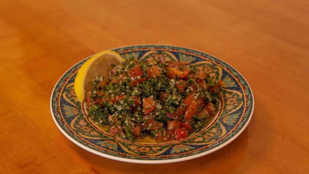 Tabouli Salads · Finely chopped parsley, tomatoes, onion, cracked wheat mixed with lemon juice, salt, and olive oil.