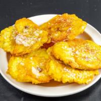 Tostones Con Ajo · Fried flattened plantains with garlic spread