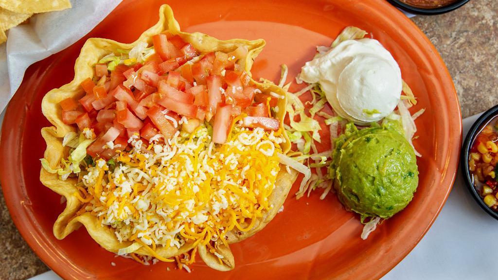 Taco Salad · A large flour tortilla shell loaded with your choice of beef and bean, chicken and rice or our veggie blend and rice. Topped off with lettuce, shredded cheese and tomato. Guacamole and Sour Cream on the side.