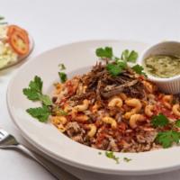 Koshary · Rice, pasta, lentils, spicy red sauce, and a side of cilantro sauce.