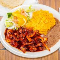Camarones Ala Diabla · Shrimp cooked on devil-style sauce, served with salad, tortillas, rice, and beans.