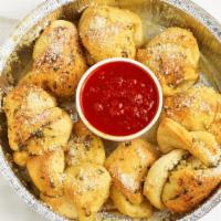 Garlic Knots (8) · Homemade dough baked, topped with our special garlic butter and mozzarella served with red s...