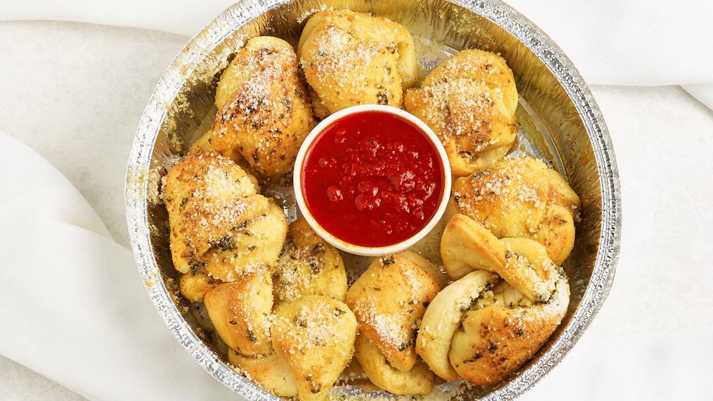 Garlic Knots (8) · Homemade dough baked, topped with our special garlic butter and mozzarella served with red sauce.