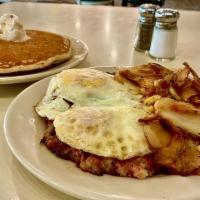 Corned Beef Hash & Eggs (Dd) · A mound of corned beef hash next to a mound of garden potatoes topped with two *eggs any sty...