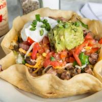Taco Salad · A crispy flour tortilla bowl filled to the brim with fresh mixed greens and topped with your...