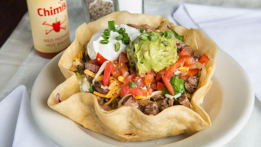 Taco Salad · A crispy flour tortilla bowl filled to the brim with fresh mixed greens and topped with your hoice of black beans or refried beans, tomatoes, cheese, guacamole and sour cream.