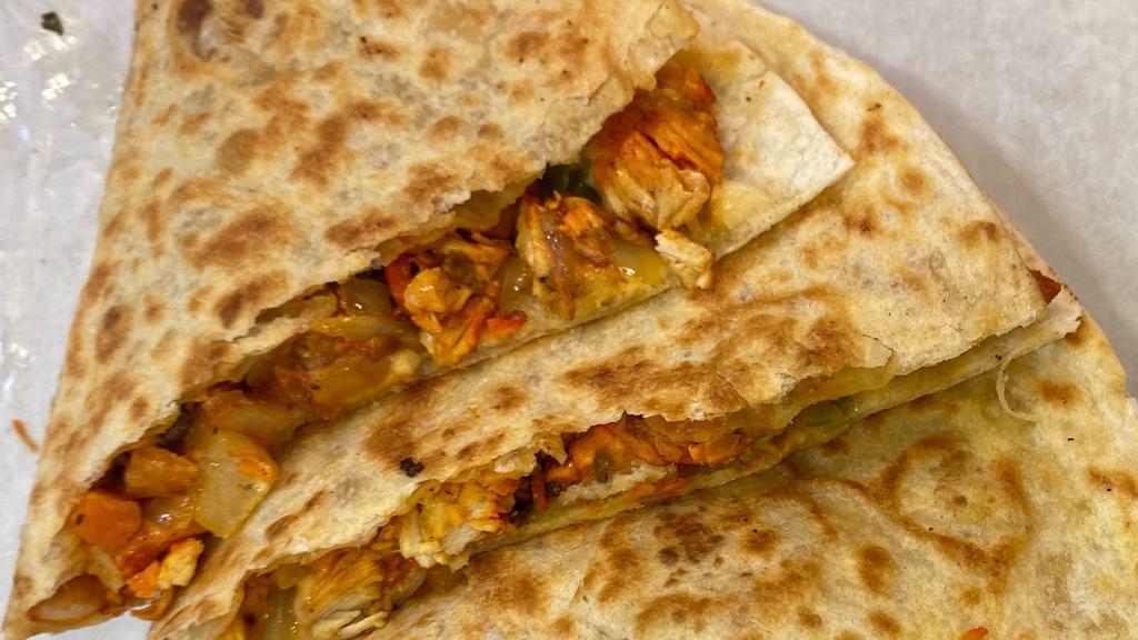 Chicken Quesadilla · Seasoned Chicken Grilled with Onions, Green Peppers, Potatoes and Mixed Veggie on a Toasted Tortilla with Cheez and Quesadilla Sauce. then we cut them into 4 slices like pizza shape.