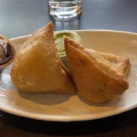 Samosa · A triangular savory pastry fried in oil, containing spiced potatoes and peas.