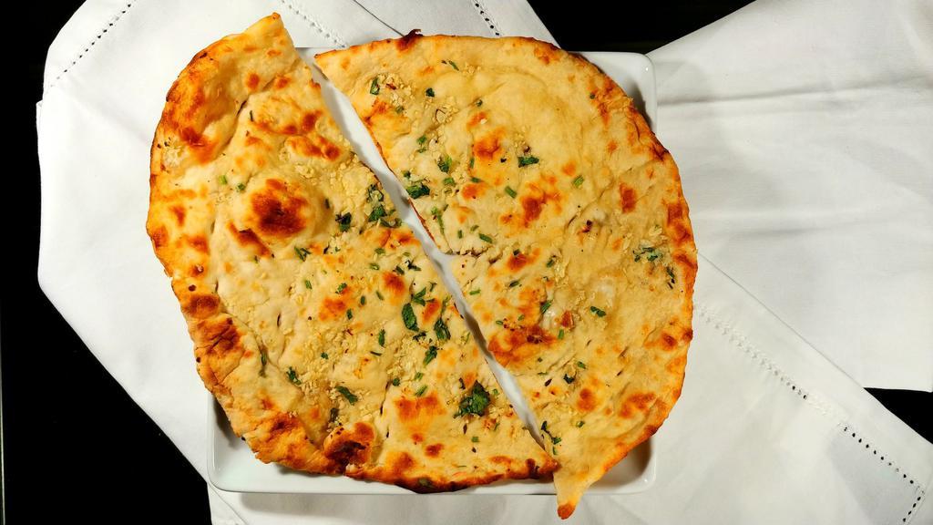 Garlic Naan · Leavened white flour bread topped with chopped garlic and butter.