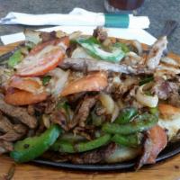 Potato Fajitas · Grilled strips of steak or chicken, onions, bell peppers and tomatoes. Served over a baked p...