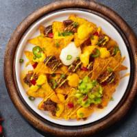 Nacho Supremacy · Salted tortilla chips doused in melted nacho cheese and topped with ground beef, jalapenos, ...