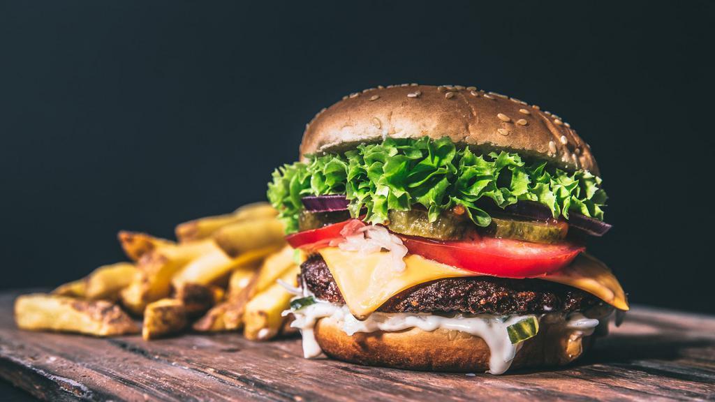 Millenium Burger · 1/2 pound burger, cheddar cheese, bacon, avocado spread, lettuce, tomato, and sriracha ranch sauce on a brioche bun.
