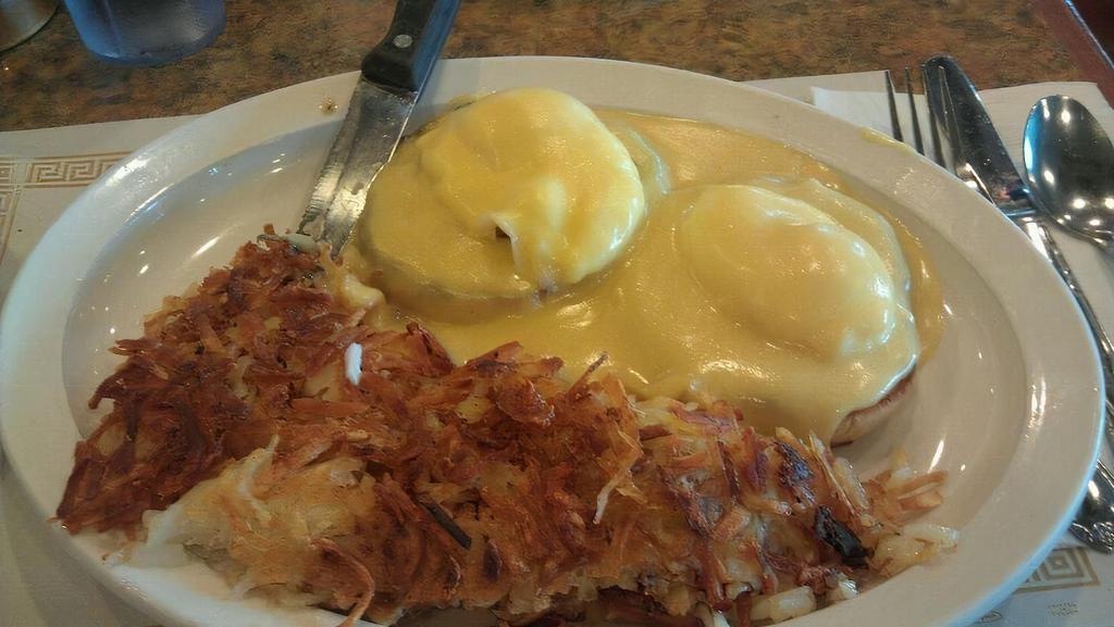 Eggs Benedict · Classic American breakfast- 2 English muffins topped with Canadian bacon and pouched eggs smothered in hollandaise sauce served with Hash browns