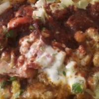 Samosa Chaat · Two samosa crushed up with chick peas on top. Plus thesiki, cilantro mint, and tamarind sauc...