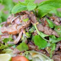 Bbq Beef Salad (Nua Nam Tok) (Spicy) · Grilled beef tossed in a chili lime dressing with roasted rice, red onions, mint leaves and ...