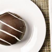 Tuxedo Bomb · A rich chocolate cake base is layered with milk chocolate and white chocolate mousse and cov...