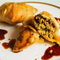 Lamb Samosa · Crisp turnover stuffed with mildly spiced ground and peas(2Pcs).