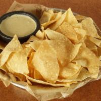 Chips & Queso · Fresh tortilla chips dusted with our southwest seasoning, warm housemade queso and pico de g...