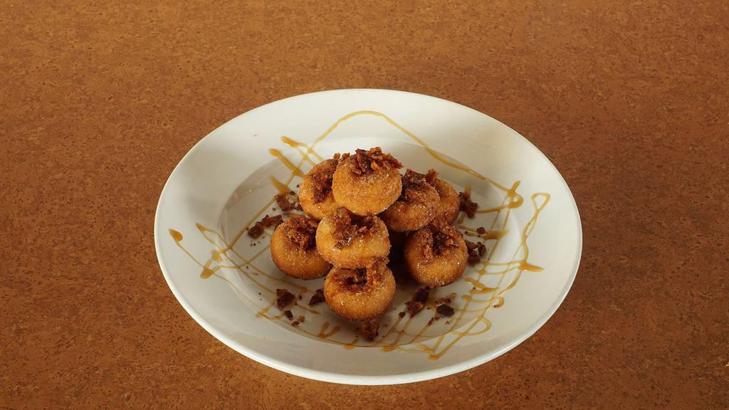 Candied Bacon Mini Donuts* · Mini donuts tossed in cinnamon sugar and then finished with crumbled candied bacon and caramel sauce drizzle.