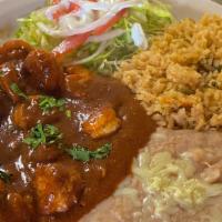Camarones A La Diabla · Grilled shrimp with a spicy sauce, served with rice, beans, lettuce, tomatoes, onions, avoca...