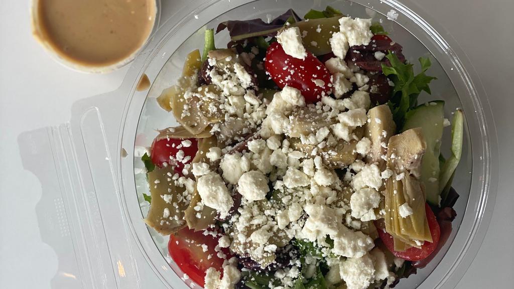 Greek Salad · mixed spring greens, kalamata olives, artichokes, feta cheese, cherry tomatoes, cucumbers, creamy tahini dressing (gf)