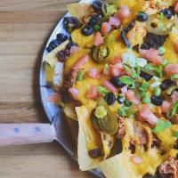 Nachos · Freshly made tortilla chips topped with ground beef, shredded chicken, cheddar, nacho cheese...