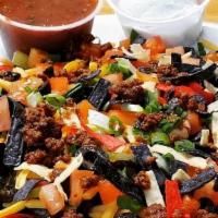 Taco Salad · Served on a bed of chopped romaine & tortilla strips, topped with scallions, tomatoes, chedd...