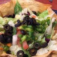 Fiesta Taco Salad · Homemade taco meat in a taco shell, topped with black olives, tomatoes, onions, sour cream, ...