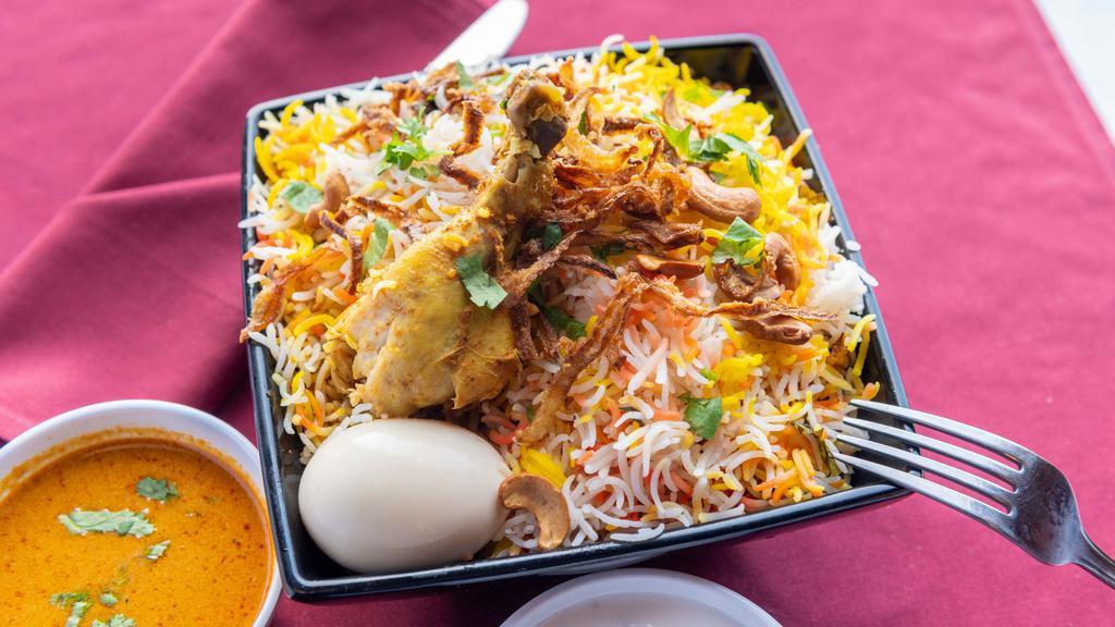 Hyderabad Chicken Dum Biryani · Chicken and basmati rice cooked in layers, flavored with saffron, served with raita and mirchi-ka-salan.
