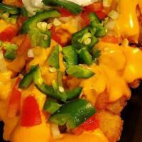Totchos · Crispy tater tots topped with Cheddar cheese sauce, tomatoes, onions, black olives, jalapeno...