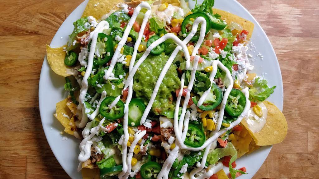 Nachos Supremos  · Nachos with chicken, ground beef and black beans. Topped with cheese dip, romaine mix, diced tomatoes, sour cream, guacamole, queso fresco, corn and jalapeños