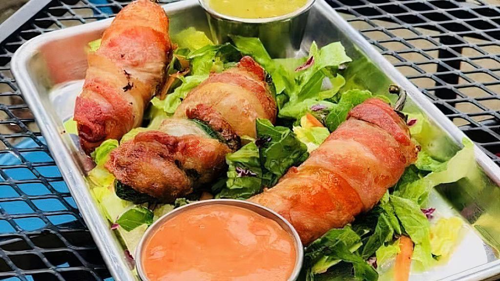 Jalapeños Poppers · Three fresh seedless jalapeño peppers filled with cream cheese, wrapped with bacon and deep fried. Topped with queso fresco and corn. Served over a bed of romaine mix.