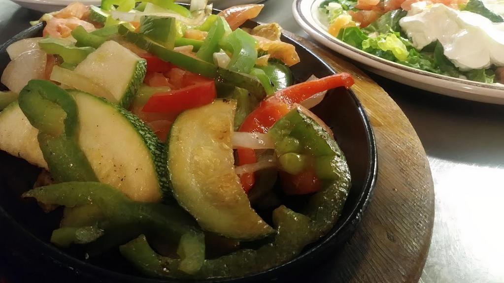 Vegetarian Fajitas · Combination of grilled bell peppers, mushrooms, tomatoes, zucchini, nopalitos, squash, and onions served with rice, black or refried beans, romaine mix, pico de gallo, sour cream, guacamole, and tortillas.