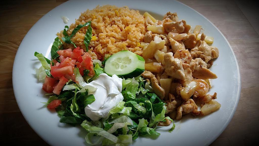 Cancun Chicken · Grilled chicken strips, shrimp, and pineapple topped with melted cheese. Served with rice, romaine mix, sour cream, tomatoes, and tortillas.