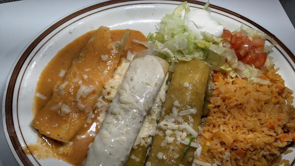 Tres Marias · One chicken, one beef, and one cheese enchilada covered with three different sauces, red, queso dip, and green. Served with rice, romaine mix, tomatoes, and sour cream.
