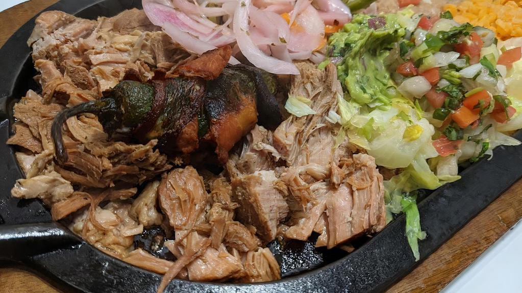 Carnitas · Pork tips served with rice, black or refried beans, romaine mix, guacamole, a jalapeño popper on top and tortillas
