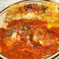 Huevos Rancheros · House-made corn tortillas with two fried eggs and hash browns smothered in our savory house-...