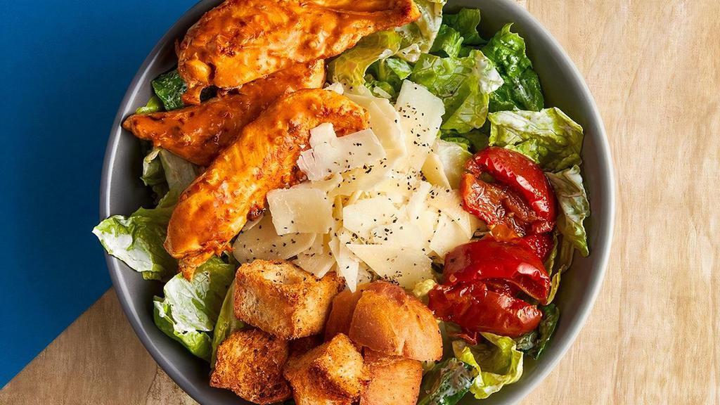 Chicken Caesar Salad · Chopped romaine tossed in our house Caesar dressing. Topped with PERi-PERi chicken, shaved parmesan, house-made croutons, black pepper, and PERi-dried tomatoes.
