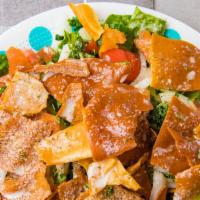 Fattoush Salad · Romaine lettuce topped with tomatoes, cucumbers, onions, fried pita chips, parsley and house...