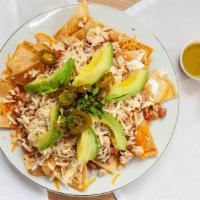 Locos Nachos · homemade tortilla chips loaded with charro beans, chicken, cheese, sour cream, avocado and p...