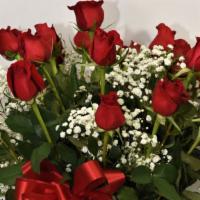 Love You Loads · 24 long stemmed red roses arranged in a clear glass vase with greens and fillers.