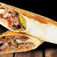 Steak Shawarma · Thin sliced marinated beef in our famous seasoning, served with tahini sauce, tomatoes and o...