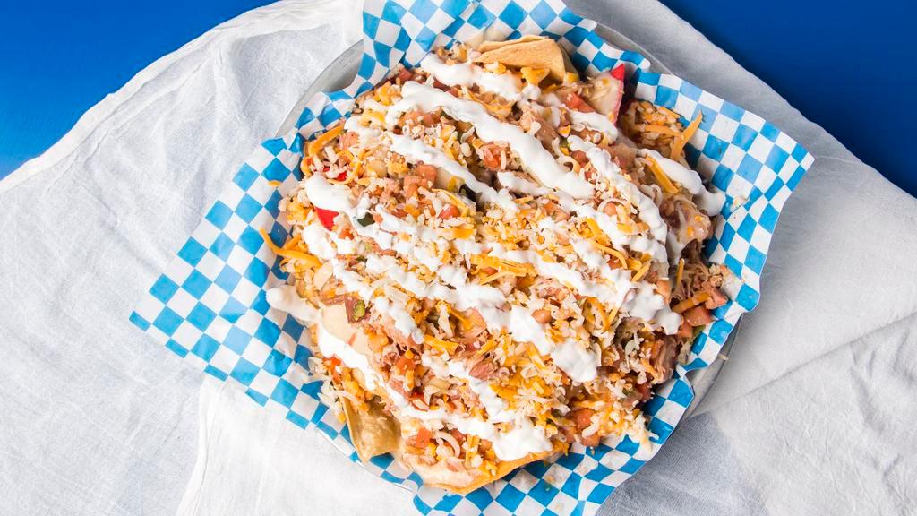 Deluxe Nachos · White queso with smoked southwest chicken and Cheddar blend served with fresh pico and sour cream.